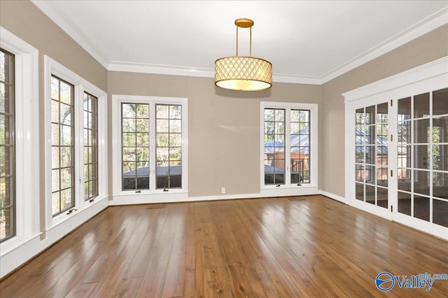 unfurnished dining area featuring hardwood / wood-style floors, visible vents, baseboards, and crown molding