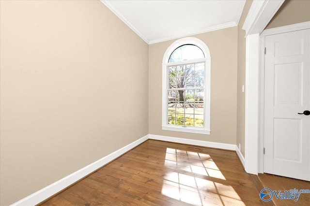 interior space featuring ornamental molding, wood finished floors, and baseboards