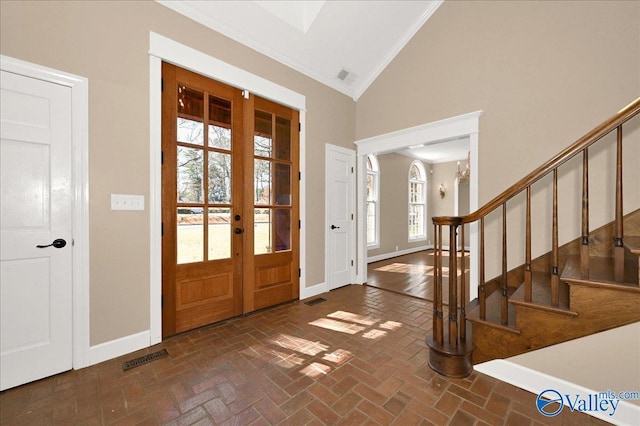 entrance foyer with brick floor, french doors, visible vents, baseboards, and stairs