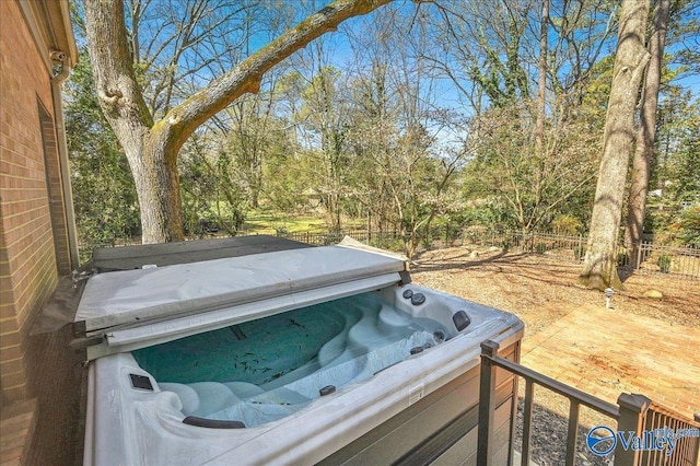 exterior details with a jacuzzi and fence