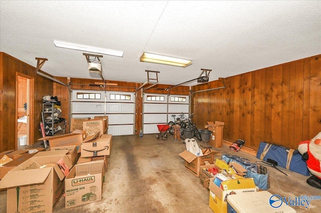 garage with a garage door opener and wooden walls