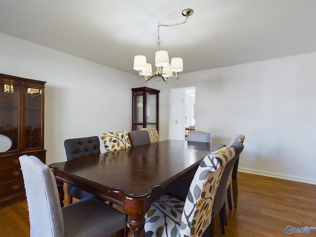 dining area with dark hardwood / wood-style floors and a chandelier