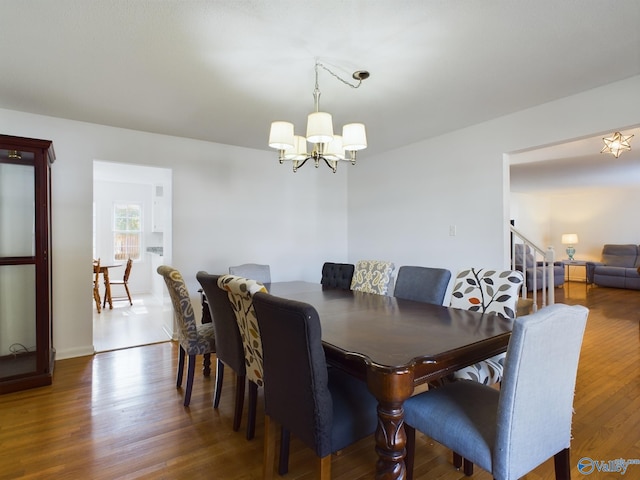 dining space featuring dark hardwood / wood-style flooring and a chandelier