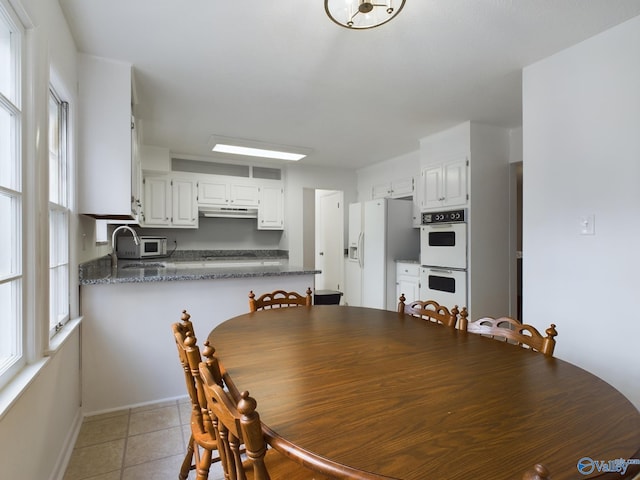 dining area featuring light tile patterned flooring and sink