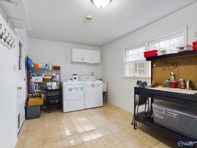 laundry room featuring washing machine and dryer, cabinets, and light tile patterned floors