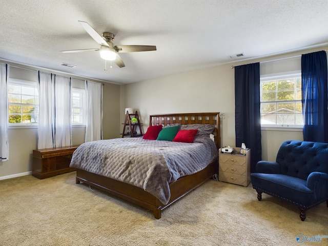 bedroom featuring a textured ceiling, light carpet, and ceiling fan