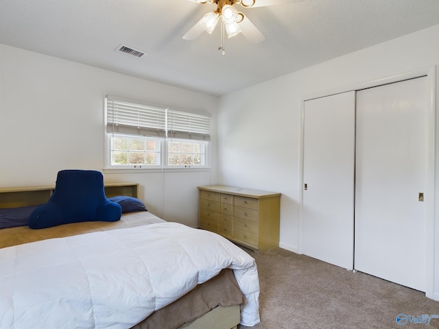 carpeted bedroom featuring a closet and ceiling fan