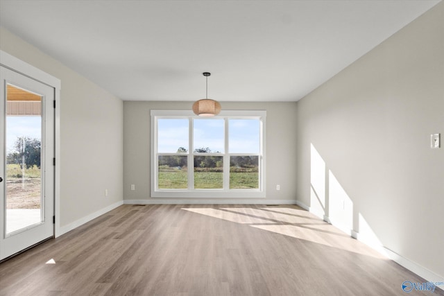 unfurnished dining area featuring light wood-type flooring