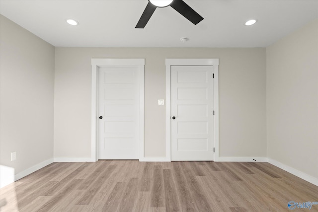 unfurnished bedroom with multiple closets, light hardwood / wood-style flooring, and ceiling fan