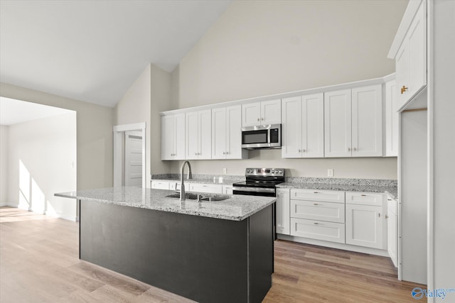 kitchen featuring white cabinets, an island with sink, stainless steel appliances, and sink