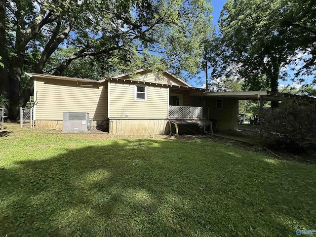 rear view of house with a lawn and cooling unit