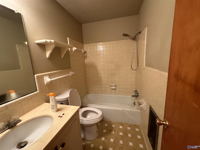 bathroom with shower / bathing tub combination, tile walls, toilet, and vanity