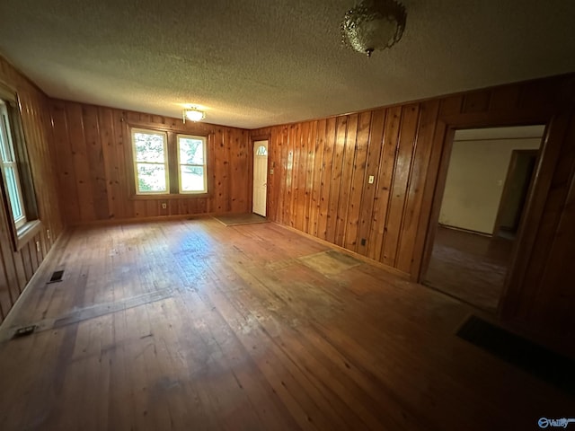 interior space with wood-type flooring, visible vents, and a textured ceiling