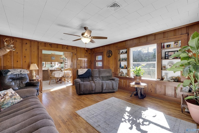 living room with light hardwood / wood-style flooring and ceiling fan