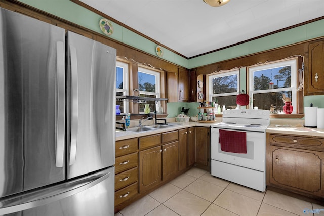 kitchen with sink, white electric stove, stainless steel refrigerator, and crown molding