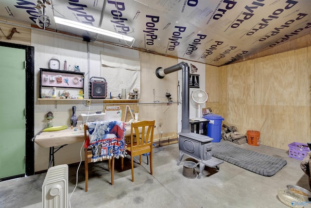 basement featuring radiator and wooden walls