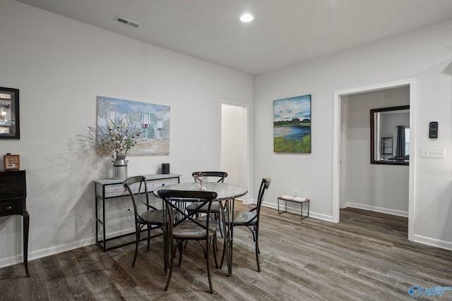 dining room featuring wood finished floors, visible vents, and baseboards
