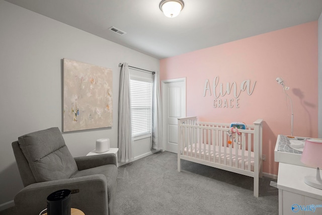 bedroom featuring a crib, baseboards, visible vents, and carpet floors