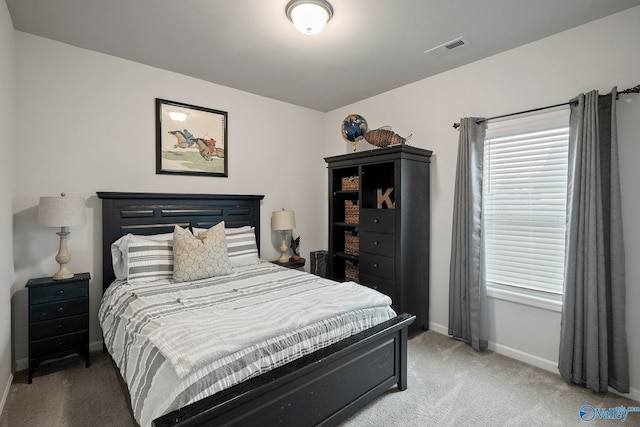 bedroom featuring baseboards, visible vents, and light colored carpet