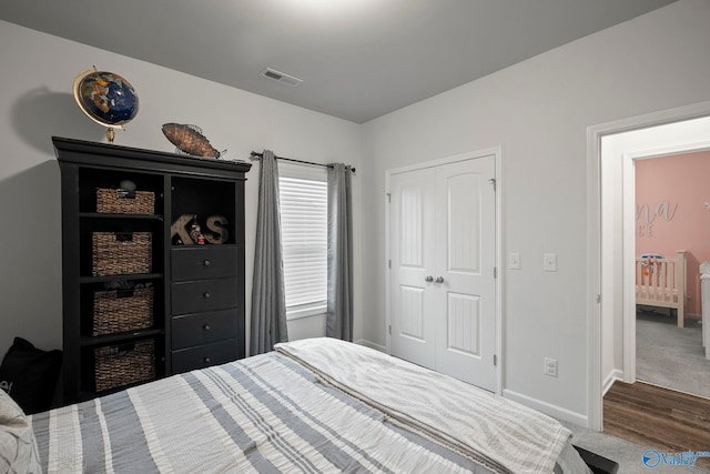 carpeted bedroom featuring baseboards, visible vents, and a closet