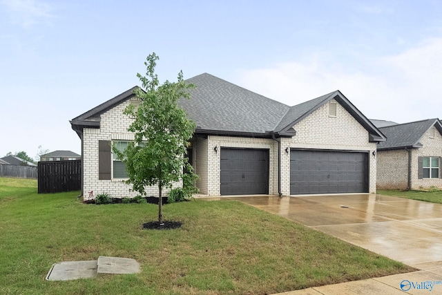 ranch-style home with fence, a front lawn, an attached garage, driveway, and brick siding