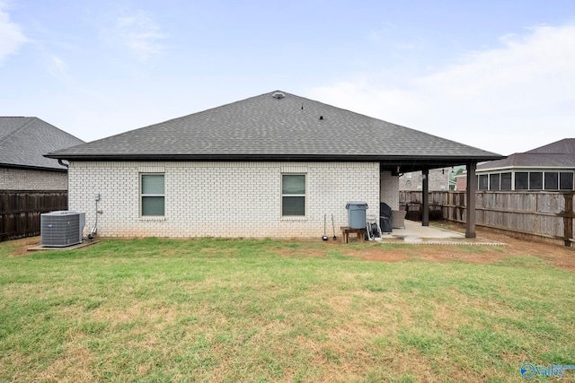 rear view of house with roof with shingles, central AC, brick siding, a patio area, and fence private yard
