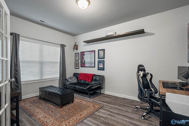 office space featuring baseboards, wood finished floors, and visible vents