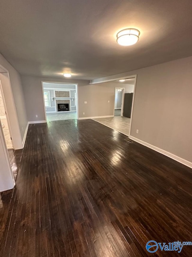 unfurnished living room with dark hardwood / wood-style flooring