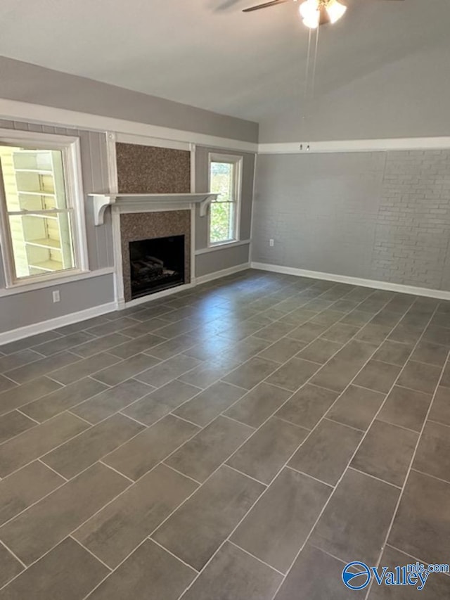 unfurnished living room featuring dark tile patterned flooring and ceiling fan