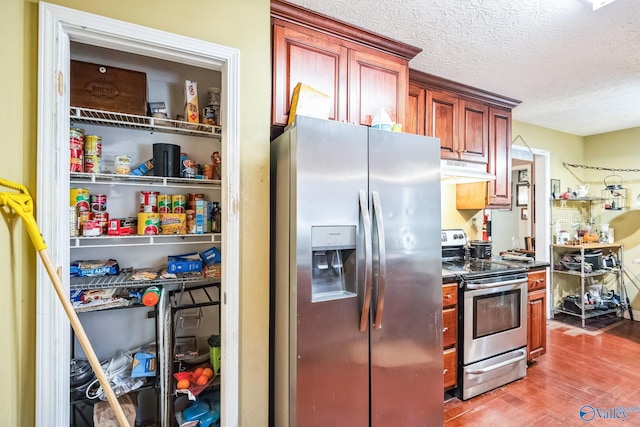 kitchen featuring wood-type flooring, a textured ceiling, and stainless steel appliances