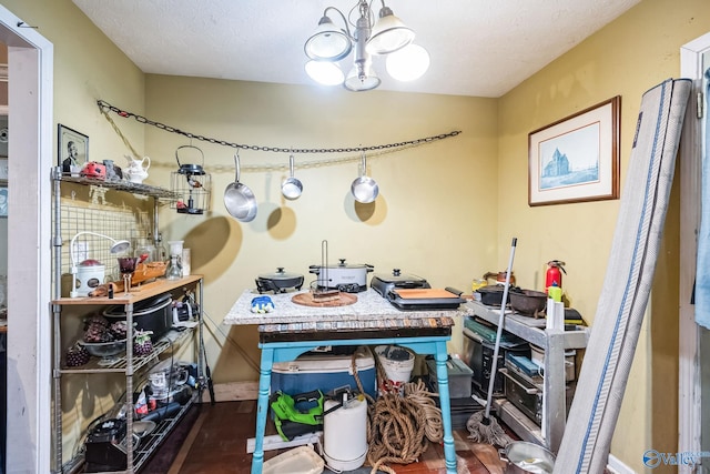 misc room featuring a textured ceiling, a notable chandelier, and a workshop area