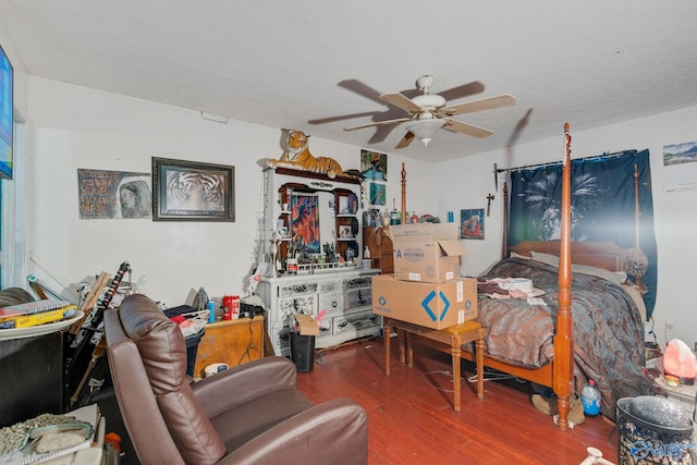 bedroom with ceiling fan, wood-type flooring, and a textured ceiling