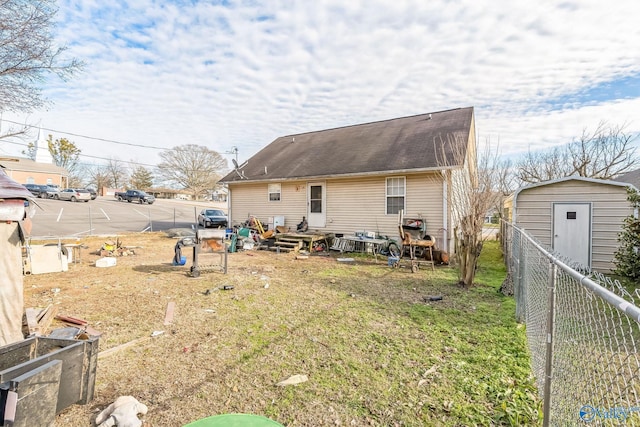 rear view of property with a storage shed