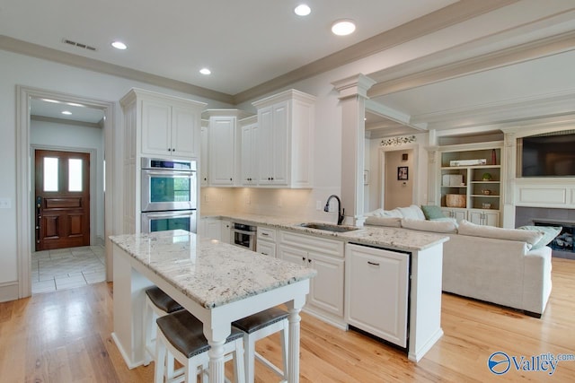 2602 Legacy Preserve Dr, Brownsboro, AL 35741 - kitchen featuring a sink, double oven, ornamental molding, open floor plan, and white cabinetry