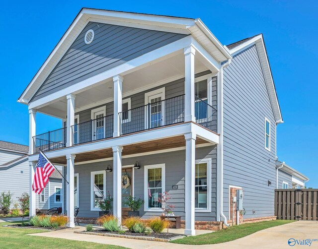 greek revival inspired property with a balcony and a porch