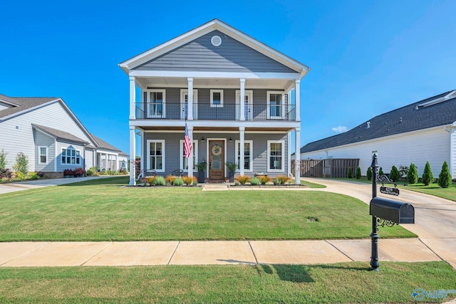 neoclassical home with a balcony, covered porch, and a front lawn