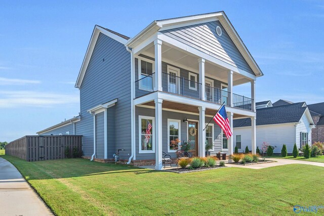 view of front of house with a front lawn and a balcony