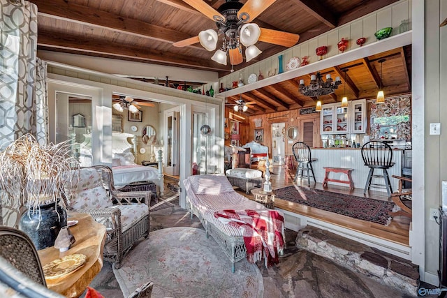 living room featuring vaulted ceiling with beams, wood ceiling, wooden walls, and ceiling fan