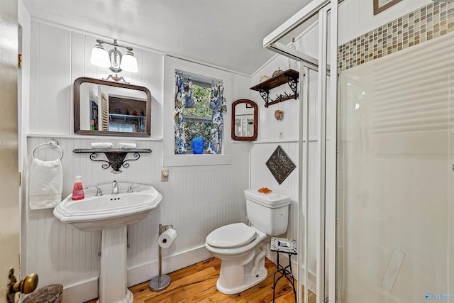 bathroom featuring wood-type flooring, sink, walk in shower, and toilet