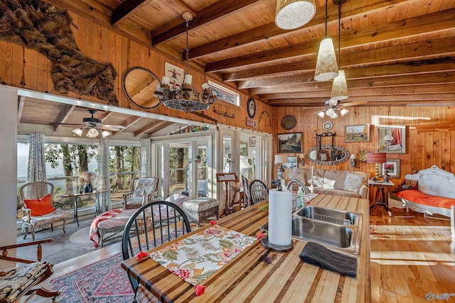 dining area featuring sink, hardwood / wood-style floors, and wood walls