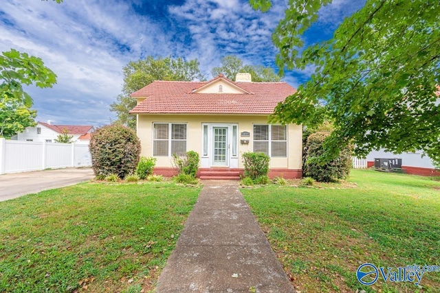 view of front of home with central AC and a front yard