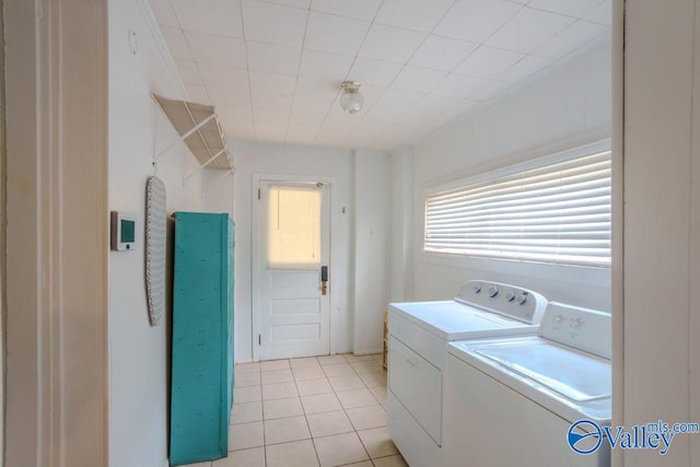 laundry area with independent washer and dryer and light tile patterned flooring