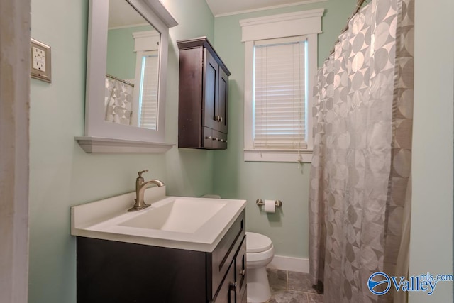 bathroom with toilet, ornamental molding, and vanity