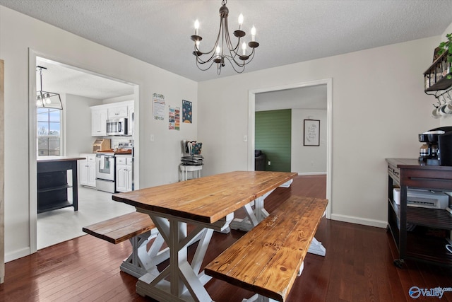 dining room with an inviting chandelier, a textured ceiling, baseboards, and wood-type flooring