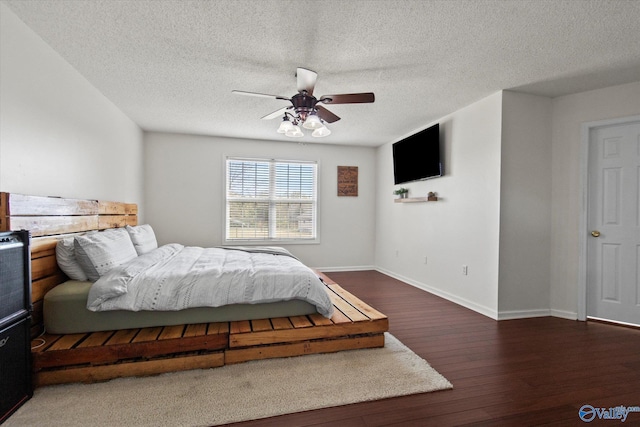 bedroom with baseboards, a textured ceiling, ceiling fan, and wood finished floors
