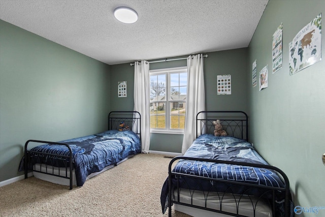 bedroom with baseboards, a textured ceiling, and carpet