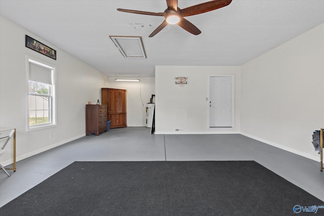garage featuring a ceiling fan, baseboards, and water heater