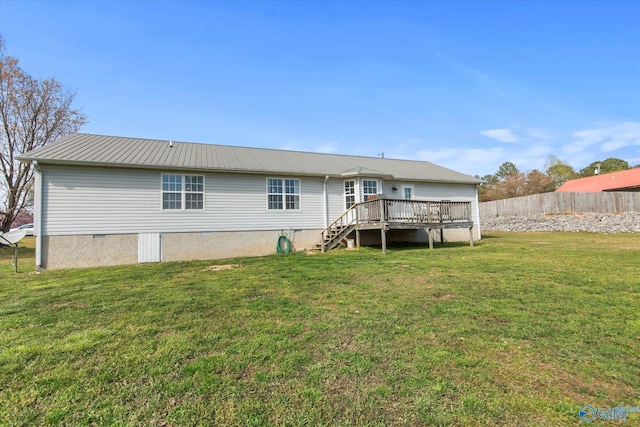 rear view of house featuring metal roof, fence, crawl space, a deck, and a lawn