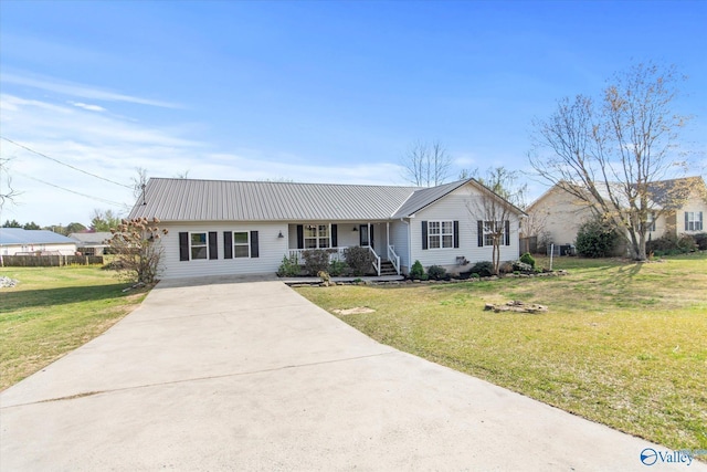 ranch-style house with metal roof, a front lawn, concrete driveway, and covered porch