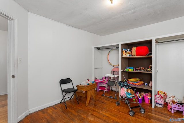 rec room featuring wood finished floors and baseboards